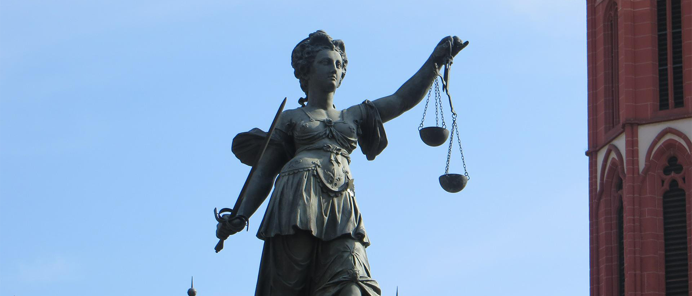 Statut tenant une balance de la justice sur fond bleu